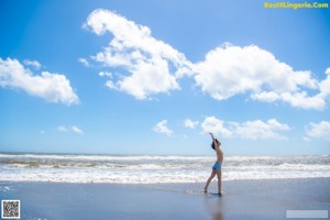 A woman in a bikini standing on the beach.