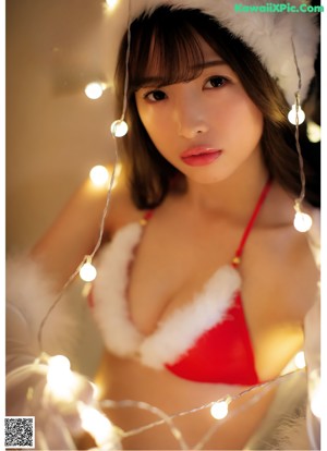 A woman in a white lingerie sitting on a bed.