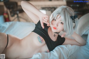 A woman in a black bikini sitting on the floor.