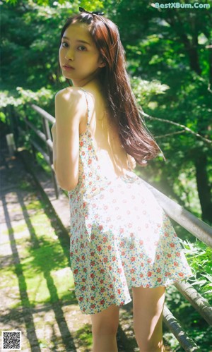 A woman in a floral dress posing for a picture.