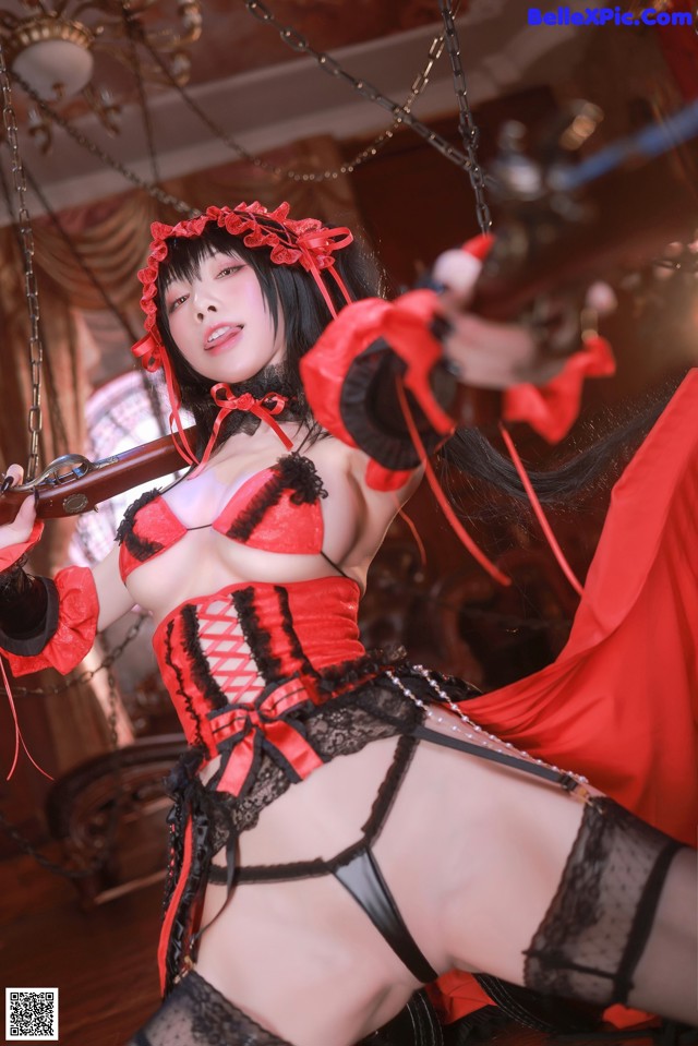 A woman in a red and black lingerie holding a rifle.