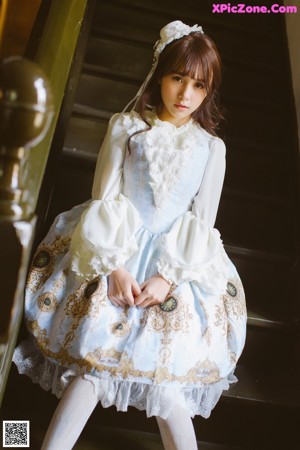 A young girl wearing a blue and white dress.