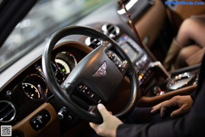 A woman sitting in the driver's seat of a car with her legs up.