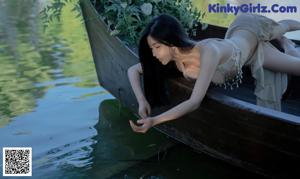 A woman in a bikini sitting on a wooden bench.