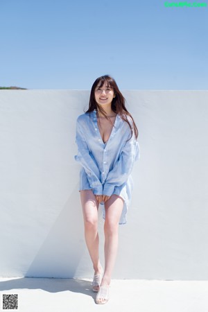 A woman in a blue shirt is posing for a picture.