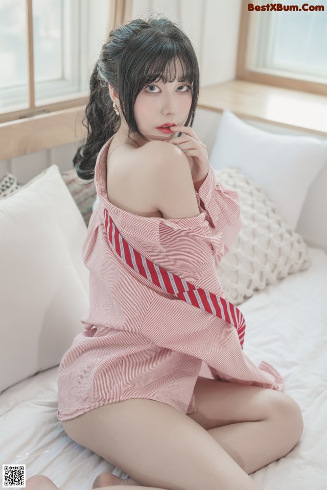 a woman sitting on top of a bed next to a window