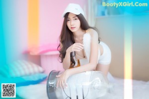 A woman in a white hat and white lingerie posing for a picture.