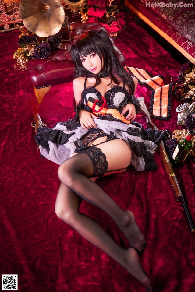 A woman in lingerie sitting on a red couch.