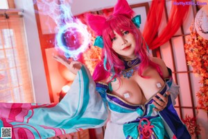 A woman with pink hair wearing a blue and pink outfit.