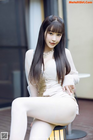 A woman in lingerie sitting on a chair in a room.