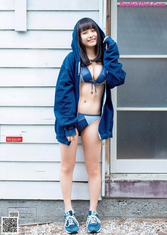 A woman in a blue hoodie and blue shorts posing for a magazine.