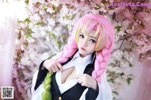 A woman with pink hair holding a sword in front of a tree.