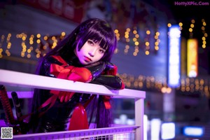 A woman in a black and red outfit holding a sword.