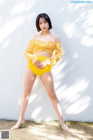 A woman in an orange bikini posing for the camera.